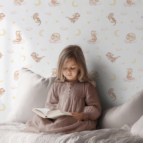 Fairytale nursery wallpaper with an adorable beige dragon, blush pink watercolor clouds and golden stars for a magical baby girl bedroom.