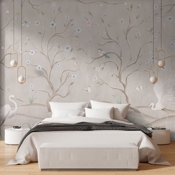 Beige chinoiserie wallpaper featuring elegant white herons, flowering tree branches, pastel pink and blue blossoms, butterflies and soft green plants.
