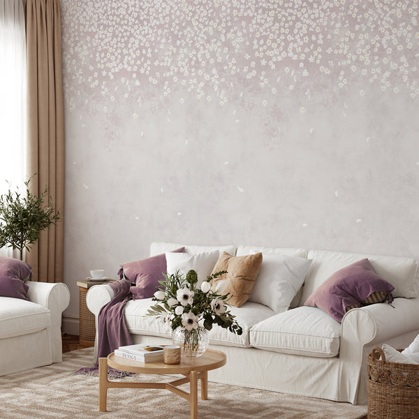Soft pink floral wallpaper featuring delicate white flowers cascading from the top over a blush watercolor background, ideal for a nursery or bedroom.
