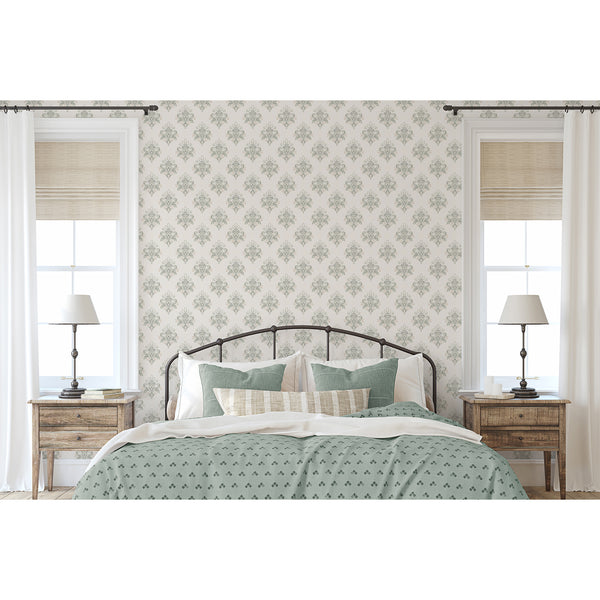 Decorative vintage wallpaper with large symmetrical damask ornaments in dusty sage green and beige, suitable for traditional and cottage style interiors.