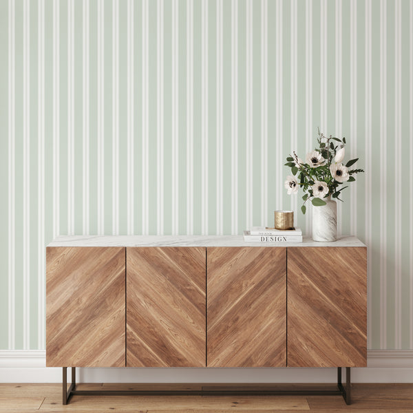 Soft sage green and white striped wallpaper with wide vertical bands and delicate pinstripe details for modern bedrooms, nurseries, and living rooms.