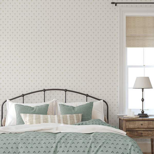Minimalist wallpaper featuring muted sage green leaf motifs and delicate dotted stems for a soft neutral room interior.