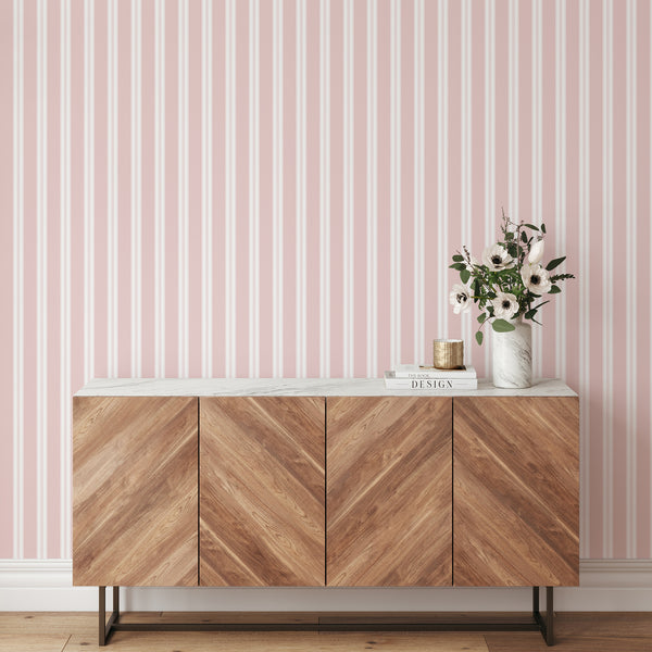 Blush pink and white striped wallpaper with wide vertical bands and delicate pinstripe details for modern bedrooms, nurseries, and living rooms.
