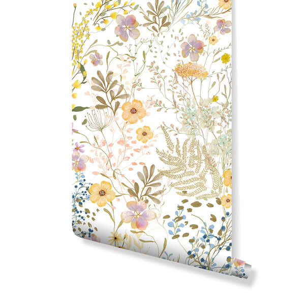 Wild Floral Wallpaper showcasing a joyful watercolor meadow in yellow, peach, lavender, pale blue, and soft green blooms over a white ground. Perfect for energizing living rooms, bedrooms, or nurseries with its hand-painted texture and irregular, airy repeat. Temporary self-adhesive option available.