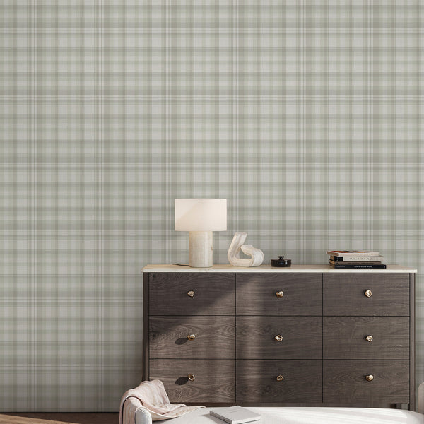 Neutral farmhouse plaid wallpaper featuring delicate intersecting light sage green stripes on a warm ivory background, creating a cozy look for living room accent walls.