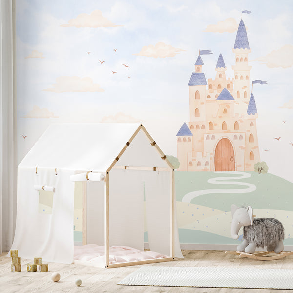 Fairytale nursery wallpaper with a beige castle, dusty blue rooftops, soft green hills and dreamy clouds for a magical kids bedroom or playroom.