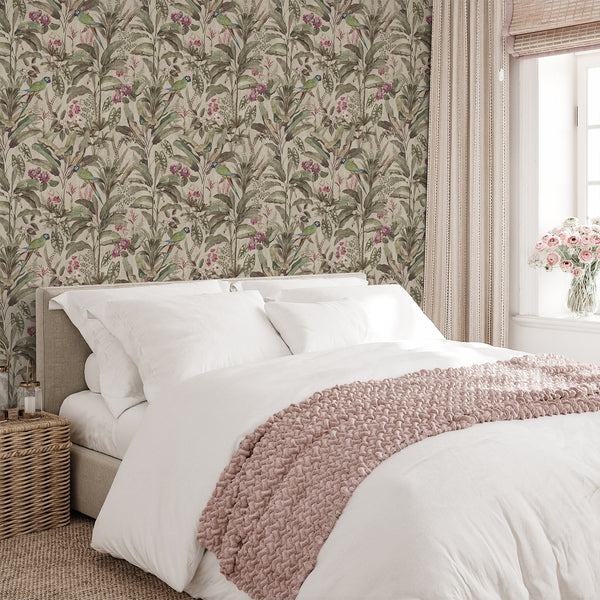 Tropical bird wallpaper with green parrots, dusty pink floral accents and dense botanical leaves for an elegant vintage-inspired living room interior.