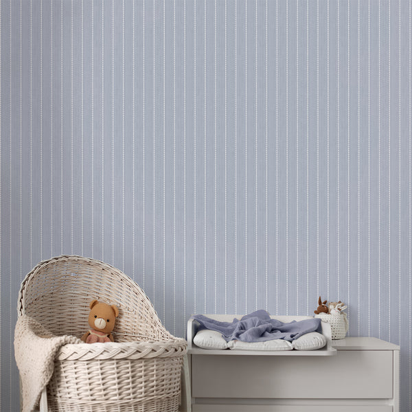 Blue striped wallpaper with repeating white pointed oval motifs arranged in evenly spaced vertical columns over a softly weathered dusty blue background.