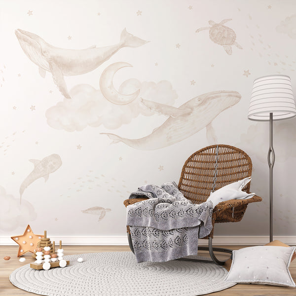 Neutral ocean animal wallpaper featuring large watercolor whales, turtles, stingray, whale shark, tiny fish, stars and a crescent moon in beige tones.