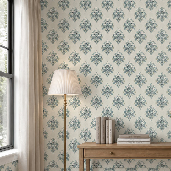 Dusty blue damask wallpaper featuring elegant symmetrical floral ornaments, scrolling leaves and decorative motifs on a soft ivory textured background.