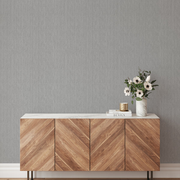 Gray wallpaper with finely striated vertical lines, adding a soft ribbed effect suitable for minimalist living spaces or bedrooms.