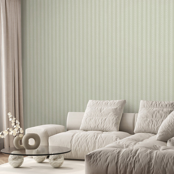 Soft sage green botanical wallpaper featuring repeating floral stripe columns, fine white line art flowers, and subtle texture for cottagecore nursery decor.