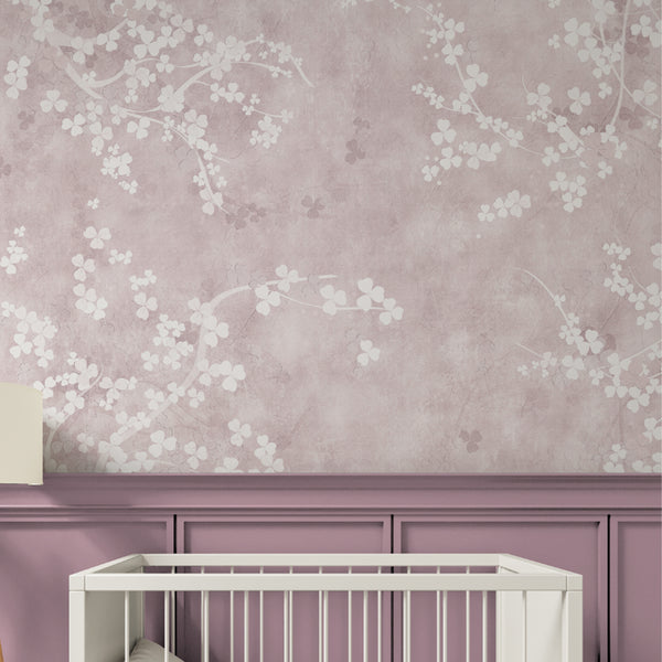 Detail of Pink Sakura wall mural showcasing soft cherry blossoms on a textured pink ground. The small floral clusters and sinuous twig lines offer a gentle, calming repeat suitable for a powder room or relaxing lounge space. Made in the USA, this temporary wallpaper is perfect for anyone seeking a modern feminine decor.