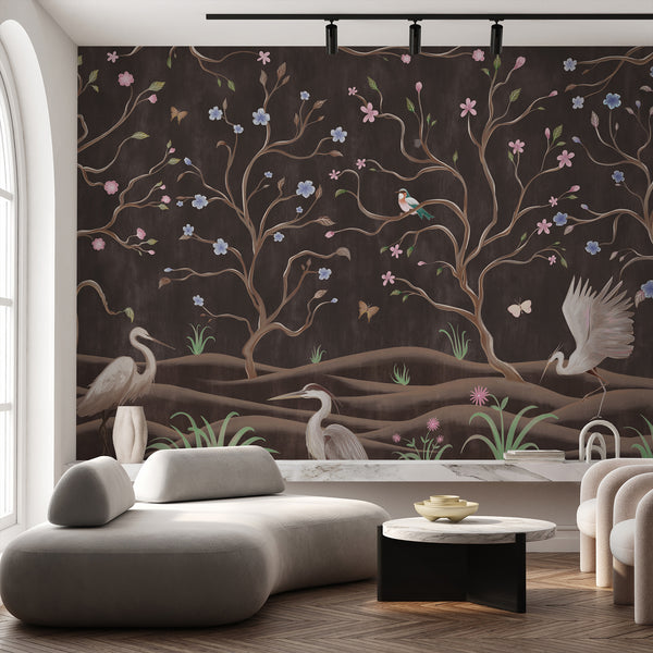 Heron bird wall mural featuring white wading birds, pink and blue blossoms, winding brown trees and butterflies on a dark brown background.