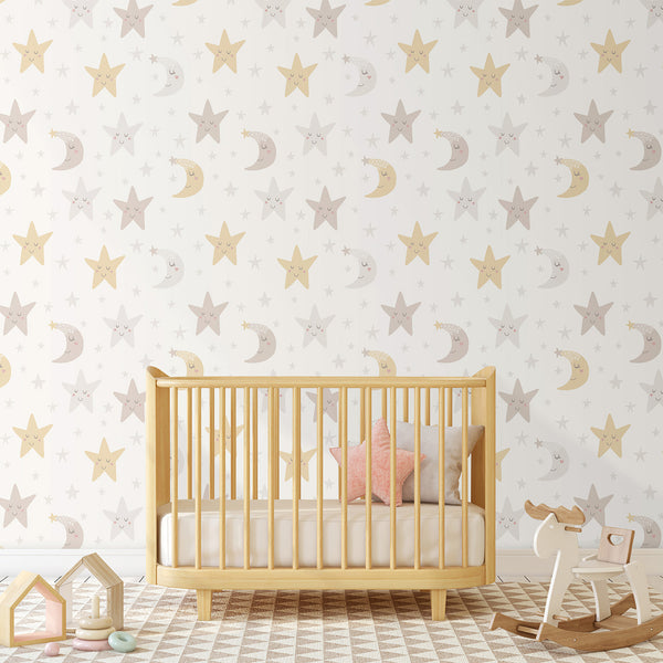 Hand-drawn Moon Stars Wallpaper featuring smiling celestial motifs in pale butter yellow and gentle grey on white. Perfect for nurseries and play areas, this temporary wallpaper offers a minimalist aesthetic with ample white space for a soothing bedtime environment. Made in the USA, it's crafted from high-quality removable material.