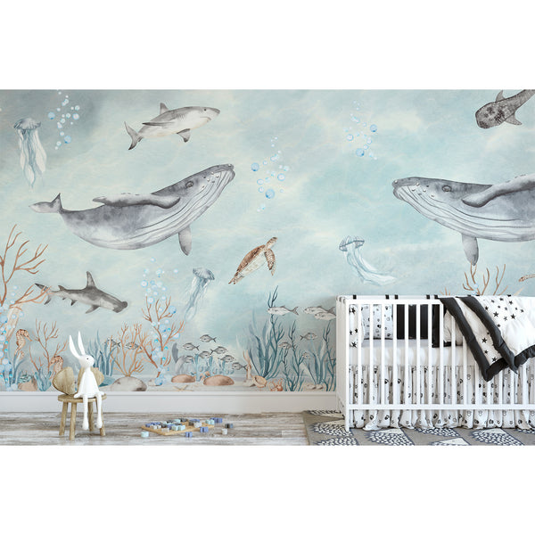 Close-up of Sea World Wall Mural showcasing watercolor marine life like rays, jellyfish, and schooling fish in pale aqua and sandy beige. This easy-to-apply, self-adhesive wallpaper is perfect for a bathroom or kids' bedroom accent wall. Its matte finish and storybook aesthetic create a calming oceanic atmosphere, ideal for eco-conscious, modern interiors.