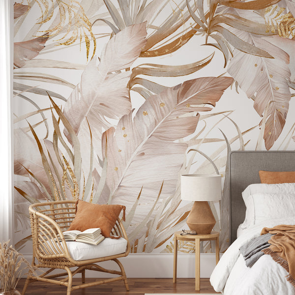 Tropical wall mural with layered banana and palm leaves in dusty blush tones and gold-fleck highlights. Suitable for a dining room or living room, this pre-pasted wallpaper exudes modern boho charm. The watercolor texture and open spaces offer an airy, elegant feature wall, crafted from high-quality materials Made in the USA.