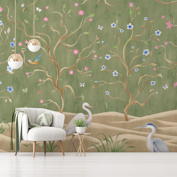Green chinoiserie wallpaper with elegant white herons, flowering tree branches, colorful birds and butterflies in a graceful nature scene.