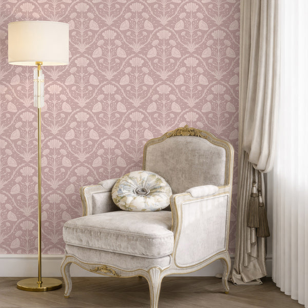 Close-up of stylized floral motifs in blush pink, creating a romantic, vintage-inspired nursery backdrop.