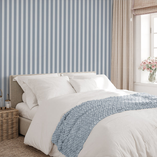 Dusty blue striped wallpaper with clean white bands and delicate vertical lines, ideal for coastal interiors, nursery walls, or modern bedroom decor.