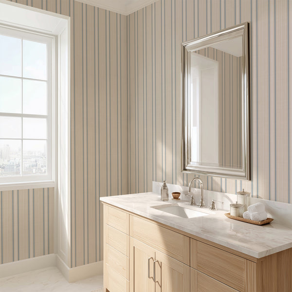 Vintage ticking stripe wallpaper with delicate blue and beige vertical lines on a warm cream background, ideal for coastal cottage and country style interiors.