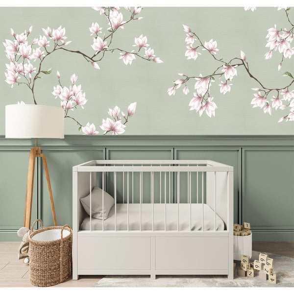 Close-up of cherry blossom branches with pale pink petals on a sage green grasscloth texture. This wall mural suits a hallway or living room, offering a gentle, flowing botanical design. Made in the USA, it's an easy-to-apply, self-adhesive wallpaper that combines eco-friendly materials with a modern, minimalist aesthetic for refined interior design.