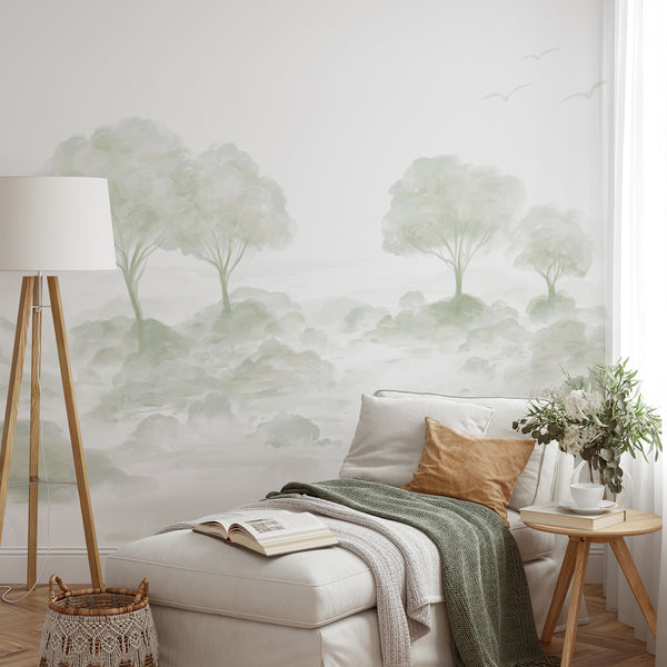 Soft sage green landscape wallpaper featuring watercolor trees, airy foliage and subtle flying birds for a minimalist bedroom or living room accent wall.
