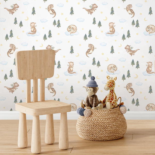 Kids room wallpaper with a cute watercolor dragon sitting on a fluffy blue cloud surrounded by woodland pine trees, yellow stars and a crescent moon.