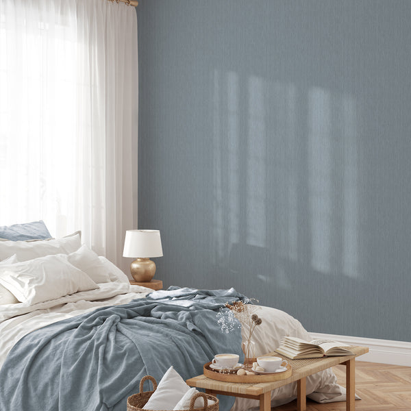 Close-up of dusty blue-grey textured wallpaper, ideal for adding depth to bedrooms and living rooms with its woven appearance.