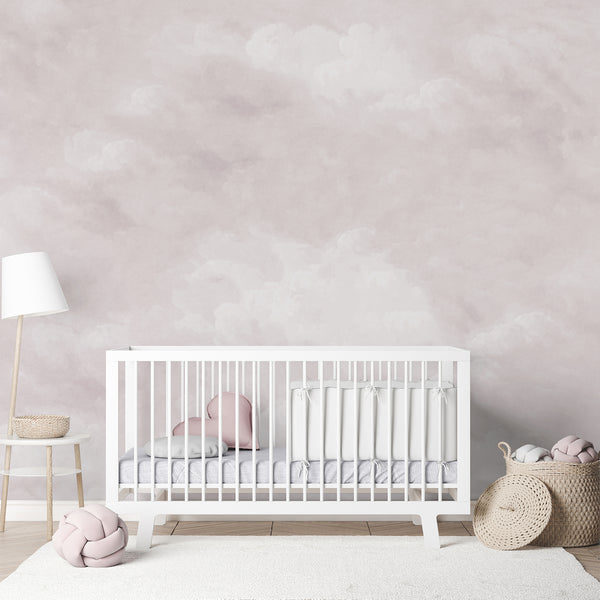 Dusty pink cloud wallpaper featuring soft white clouds across a dreamy muted sky, creating an airy backdrop for a peaceful nursery or bedroom.