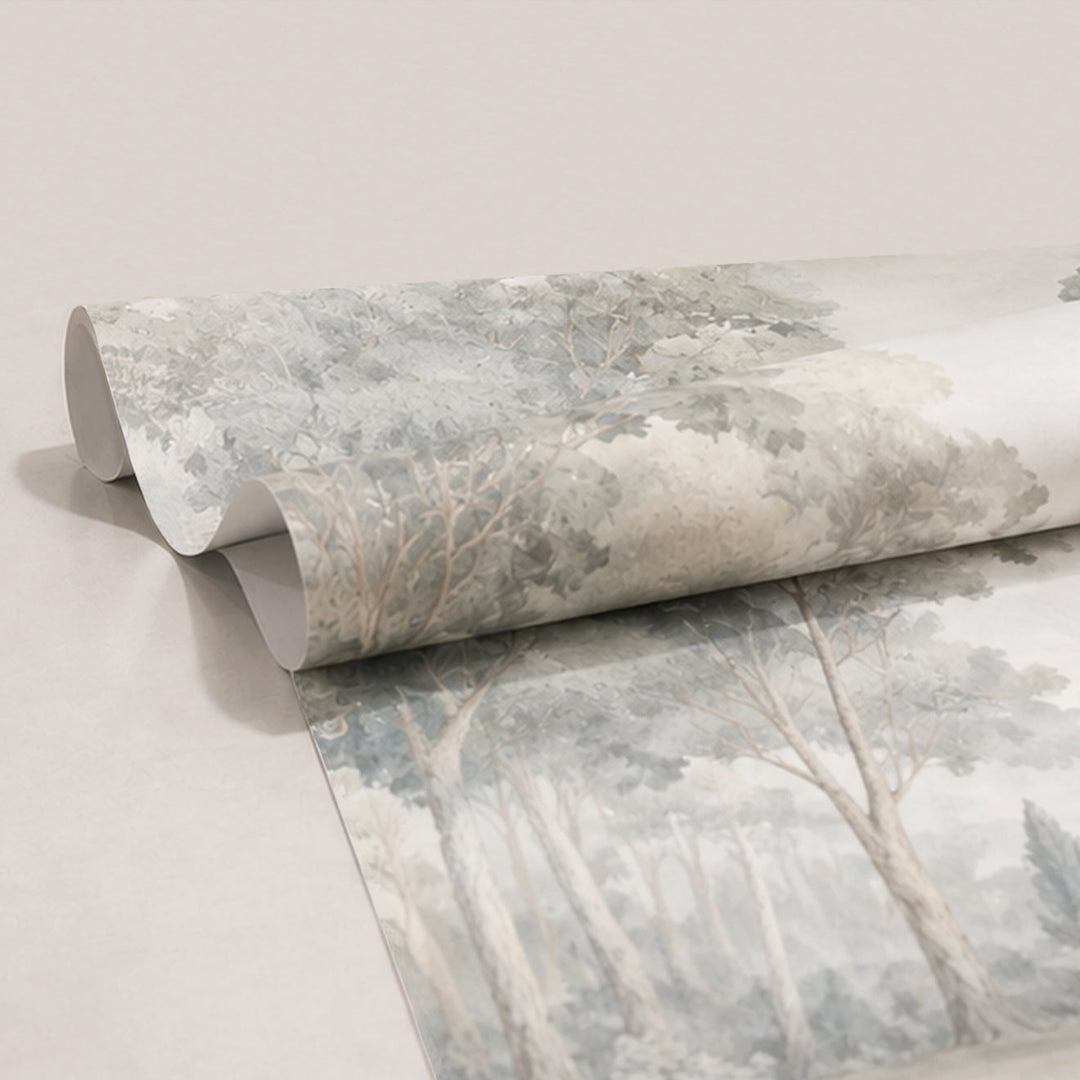 A roll of wallpaper featuring a muted, classical landscape print of trees and foliage in soft gray, beige, and off-white tones, partially unrolled to display the pattern.