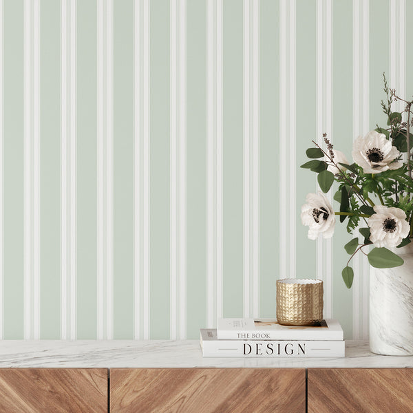 Modern farmhouse wallpaper in soft sage green and white with refined vertical stripes, creating a clean backdrop for nurseries and elegant interiors.