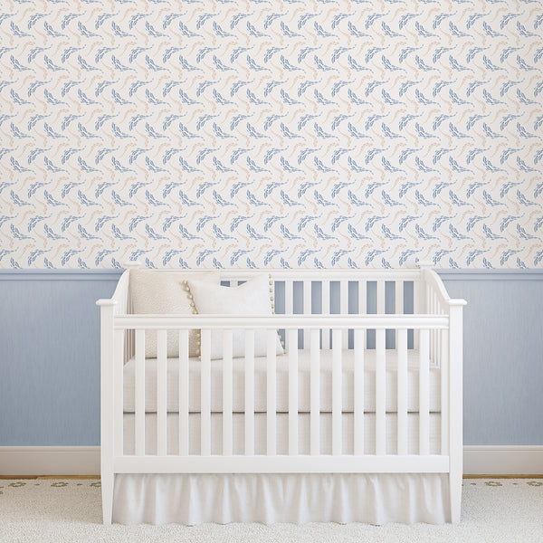 Watercolor ocean wallpaper with blue and beige fish swimming in curved schools, ideal for a nautical nursery, kids bedroom, or playroom.