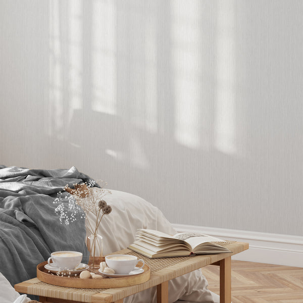 Elegant Light Gray Vertical Texture Wallpaper with fine striations on a pale gray background. Its fabric-like finish and matte surface make it suitable for modern living spaces, offering a neutral backdrop that is easy to apply, reposition, and ideal for renters.
