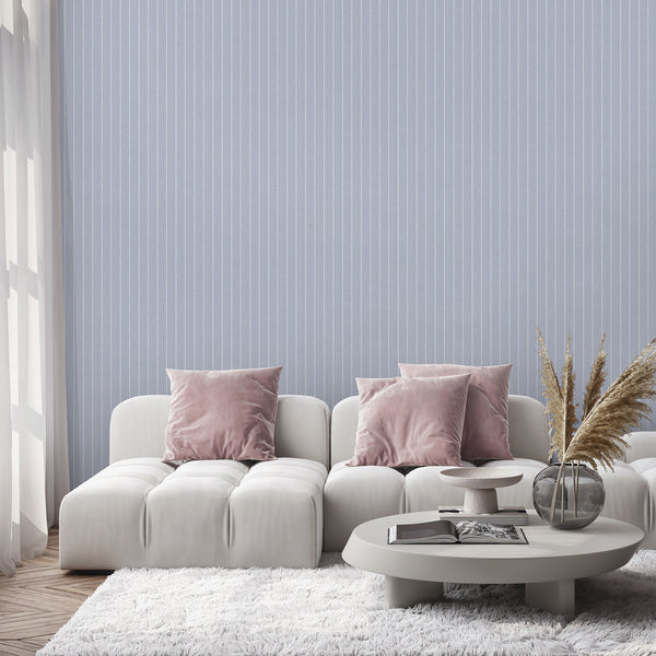 Peel and stick wallpaper with a repeating geometric oval pattern in white against a dusty blue background with fine vertical weathered texture effects.