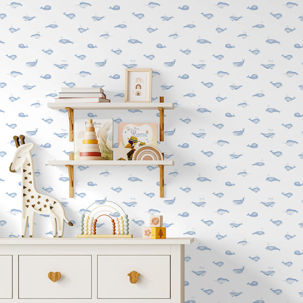 Minimal ocean nursery wallpaper featuring a friendly blue whale with a white belly and soft watercolor details on an airy white background.