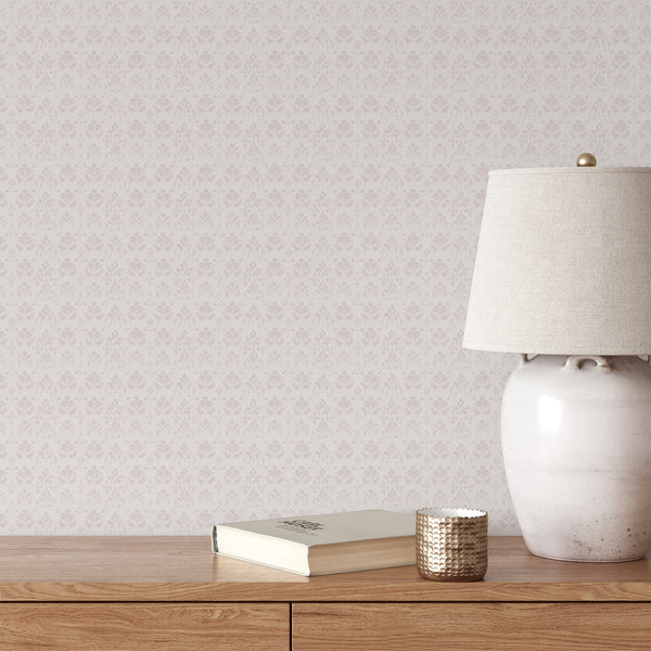Dusty pink damask wallpaper with a small repeating floral pattern on a soft white background and subtle distressed texture for elegant bedroom decor.