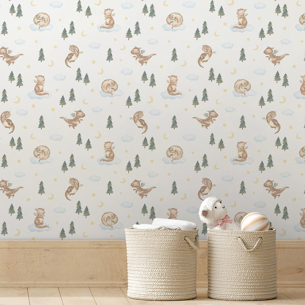 Fantasy kids wallpaper featuring a friendly watercolor dragon with evergreen trees, pale blue clouds, golden stars and a moon for a cozy nursery interior.