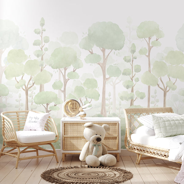 Neutral nursery with sage green forest wall mural in a soft woodland setting.