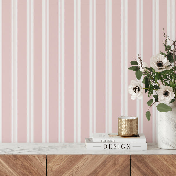 Preppy wallpaper in soft blush pink and white with refined vertical stripes, creating a bright backdrop for nurseries and stylish girls bedrooms.