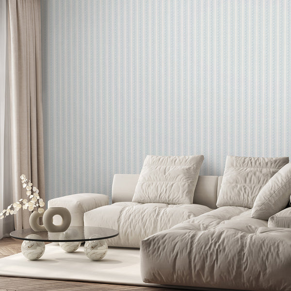 Light blue striped wallpaper with white botanical vines and delicate floral motifs, designed for a cozy nursery, bedroom, or living room wallpaper look.