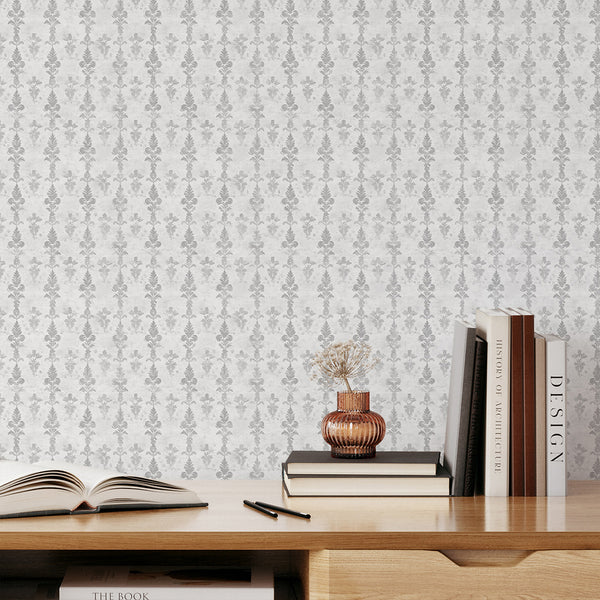 Close-up of gray damask motifs on a pale off-white ground, offering a soft, vintage-washed texture for refined interiors. The pre-pasted wallpaper's narrow pattern is ideal for creating a sophisticated accent wall in hallways or living rooms.