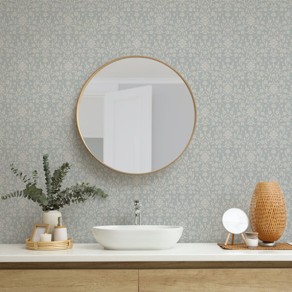 Dusty blue floral damask wallpaper featuring large cream flowers, flowing botanical vines and decorative leaves on a muted blue background with woven texture.