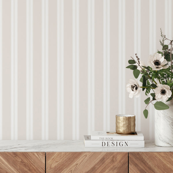 Beige striped wallpaper with wide ivory bands and delicate pinstripe details, creating a soft neutral look for bedrooms, nurseries, and living rooms.
