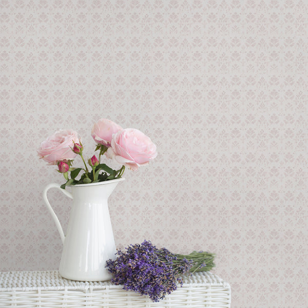 Dusty pink damask wallpaper with a small repeating floral pattern on a soft white background and subtle distressed texture for elegant bedroom decor.