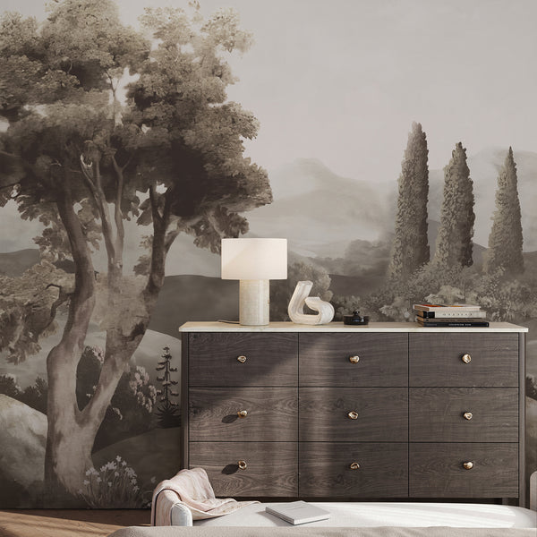 Brown wall mural with an antique style countryside panorama, cypress trees and misty hills adds depth and classic charm to a neutral interior.
