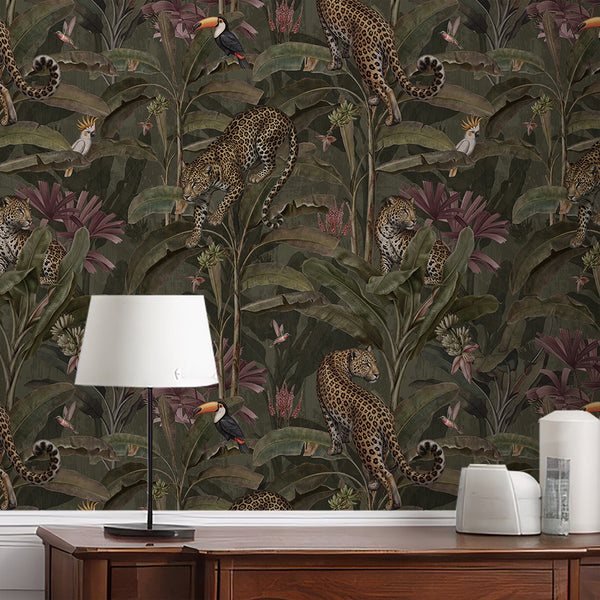 Dark botanical safari wallpaper with detailed leopards, plum pink tropical plants, lush green banana leaves and exotic birds for maximalist interiors.