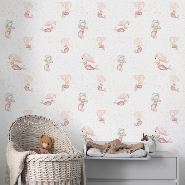 Pink mermaid nursery wallpaper featuring sweet watercolor mermaids in soft blush, muted coral, and dusty aqua tones. This removable peel and stick wallpaper adds playful coastal charm to nurseries and kids' bedrooms, creating an under-the-sea look that is gentle and airy, ideal for pastel-themed decor.