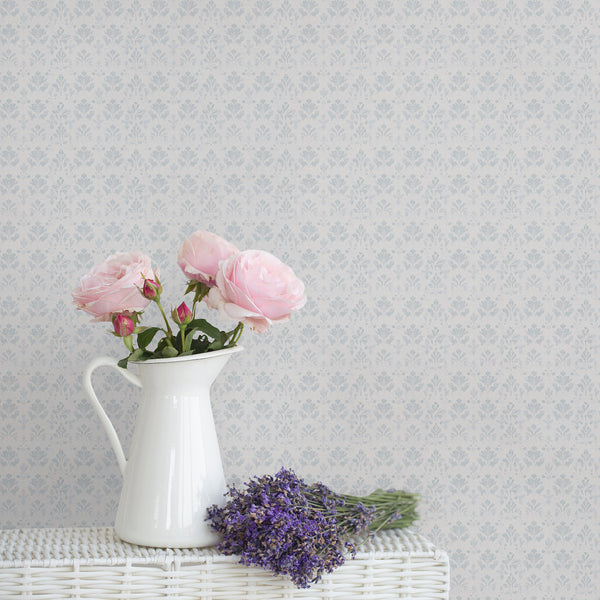 Dusty blue damask wallpaper with a small repeating floral pattern on a soft white background and subtle distressed texture for vintage bedroom decor.