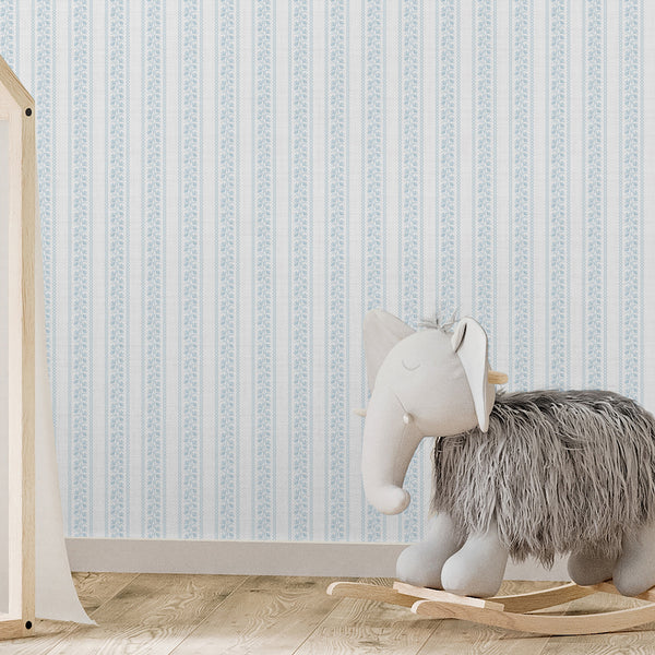Blue nursery wallpaper with slender floral columns, fine wavy stripe borders, and a gentle textured background for farmhouse or French country rooms.